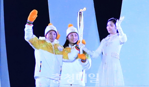 지난 9일 평창 올림픽스타디움에서 열린 2018 평창동계올림픽 개막식에서 남북 아이스하키 단일팀 북한 정수현과 남한 박종아가 김연아에게 성화를 전달하고 있다.