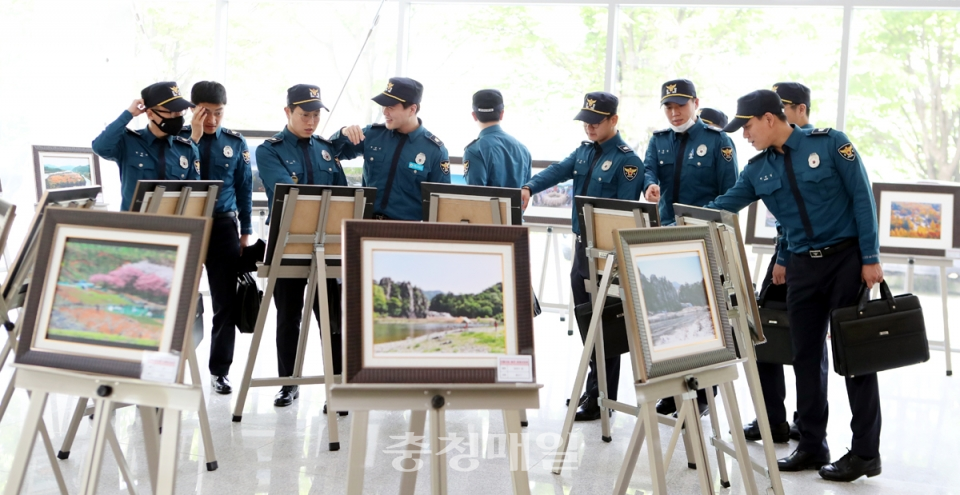 중앙경찰학교 교육생들이 전시된 충주관광전국 사진공모전 우수작품을 관람하고 있다.