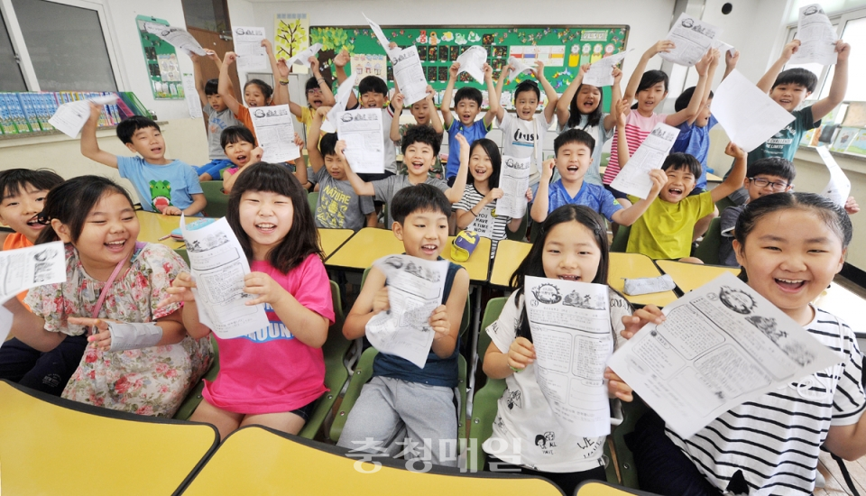 지난 13일 충북 청주경산초등학교 3학년1반 학생들이 방학식을 마친 뒤 방학 생활 계획표를 들어 보이며 즐거워하고 있다.