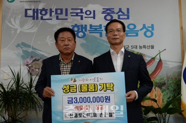 신흥토건 손근철(왼쪽) 대표가 음성군에 이웃돕기 성금을 기탁하고 조병옥 군수와 기념촬영을 했다.