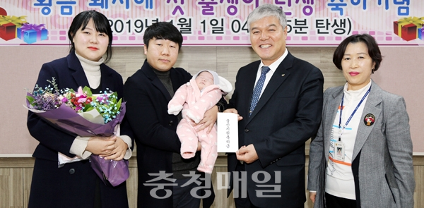 문정우(오른쪽 두번째) 금산군수가 올해 첫 출생아 가족에게 출산지원금과 선물꾸러미를 전달한 뒤 기념촬영하고 있다.