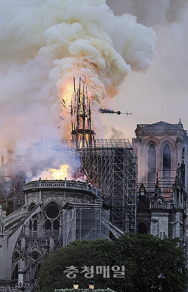 프랑스 파리의 랜드마크인 노트르담 대성당의 중앙 첨탑이 15일(현지시간) 화재로 무너지고 있다. 십자가가 세워져 있는 첨탑의 꼭대기 부분이 쓰러져 아래로 떨어지는 순간이 카메라에 포착됐다.  뉴시스