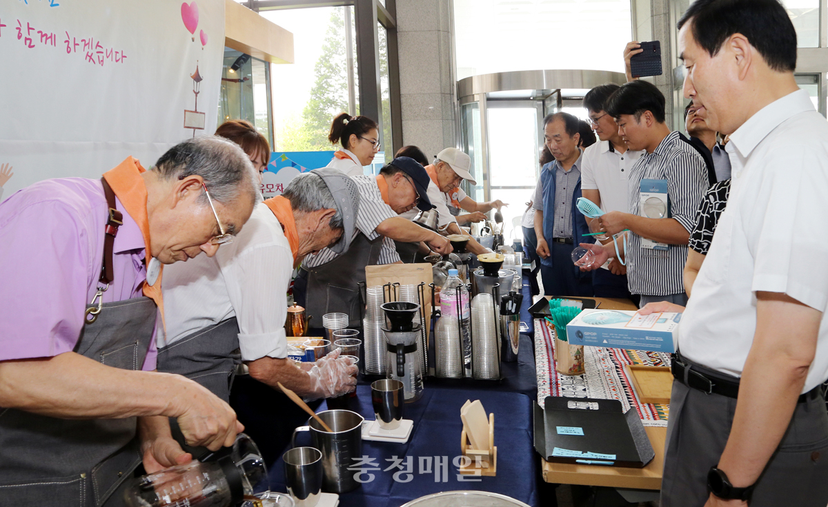 충주시치매안심센터 바리스타 카페 운영에 참가한 치매가족들이 시민들과 공무원들에게 직접 만든 커피를 대접하고 있다