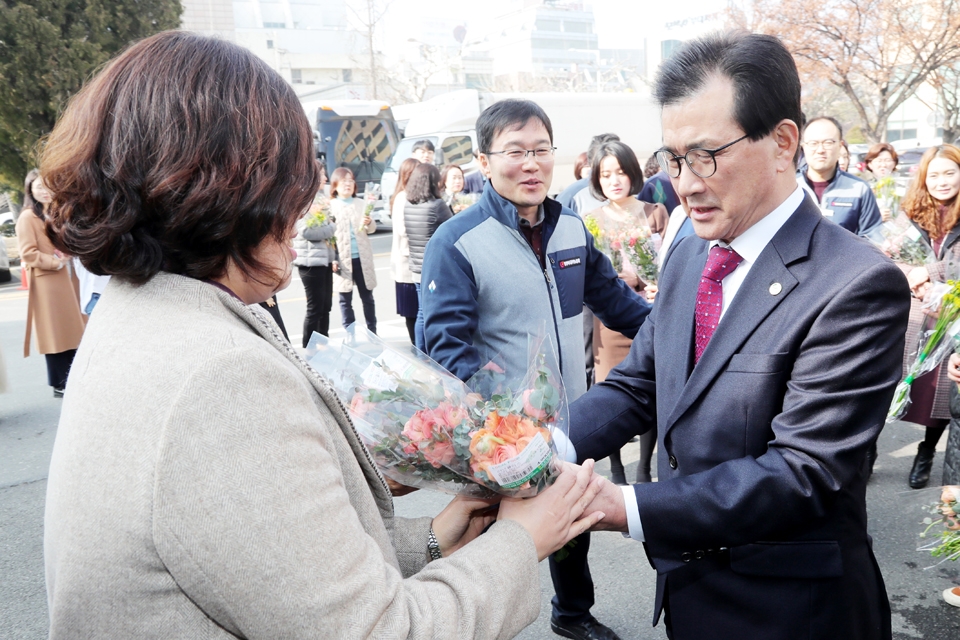 충북도는 지난 14일 도청광장에서 화훼농가 돕기 일일 직거래장터를 열었다. 이시종(오른쪽) 충북지사가 꽃다발을 구입해 직원에게 전달하고 있다.
