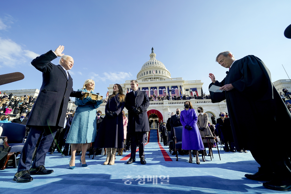 조 바이든(왼쪽) 미국 대통령 당선인이 20일(현지시간) 미 의회 의사당에서 부인 질 바이든이 들고 있는 성경에 손을 얹고 존 로버츠(오른쪽) 대법원장 앞에서 제46대 미국 대통령 취임 선서를 하고 있다.
