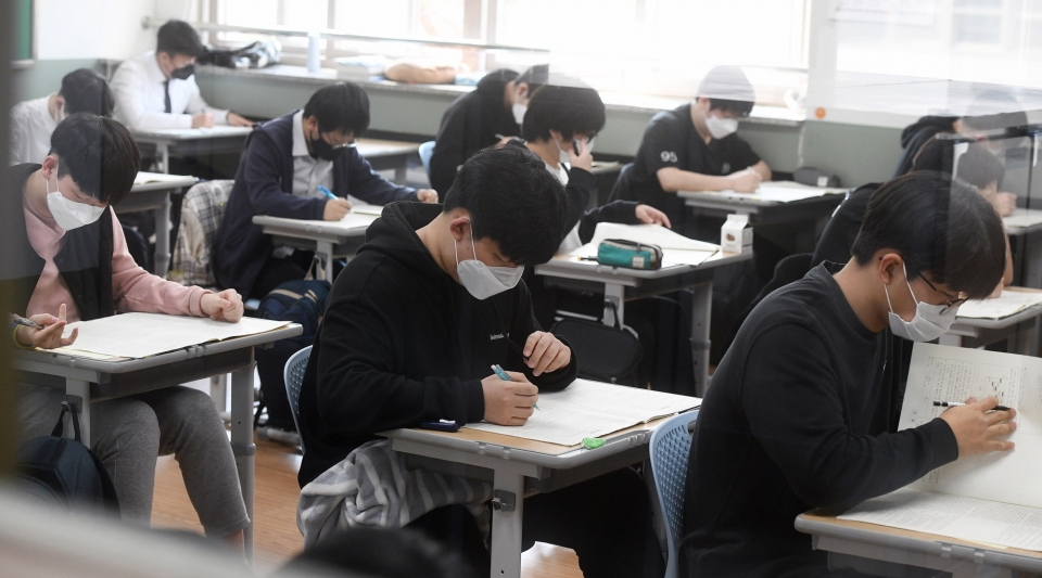 올해 첫 고3 전국연합학력평가가 실시된 25일 충북 청주고등학교에서 3학년 학생들이 마스크를 착용하고 시험문제를 풀고 있다.  오진영기자