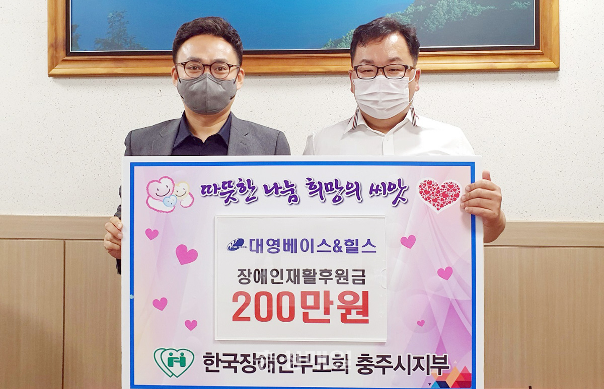 ㈜대영베이스 류두열(왼쪽) 대표가 한국장애인부모회 충북 충주시지부 홍석주 지부장에게 후원금을 전달하고 기념촬영을 했다.