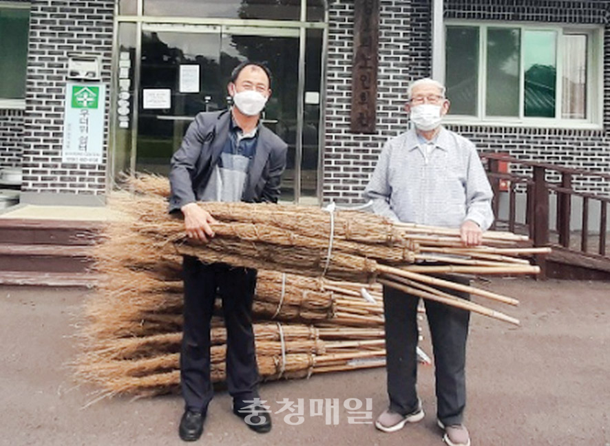 대나무 비 200자루를 기증한 충남 청양군 조한복(오른쪽)옹이 김기찬 정산면장과 기념 촬영을 하고 있다.