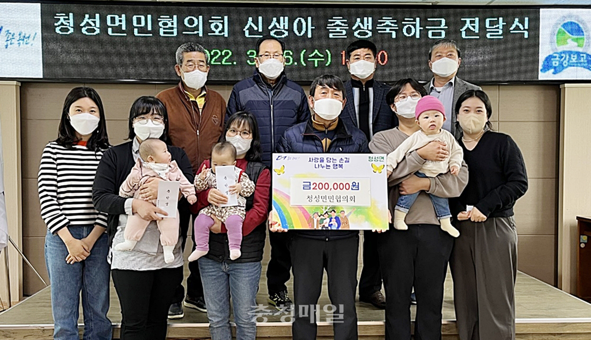 충북 옥천군 청성면민협의회가 2021년 출생아 4명에게 축하금을 전달한 뒤 기념 촬영을 하고 있다.