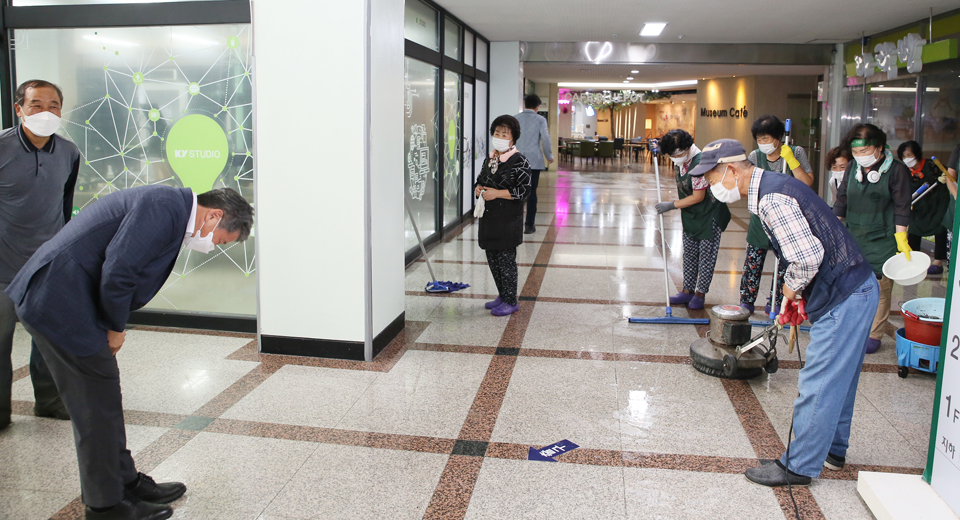 김용하(왼쪽) 건양대 총장이 지난 9일 임기 첫 업무로 교내에서 바닥 왁스작업을 진행하는 환경미화직원을 찾아 인사하고 있다.